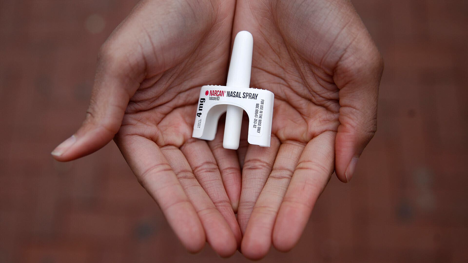 hands hold Narcan nasal spray
