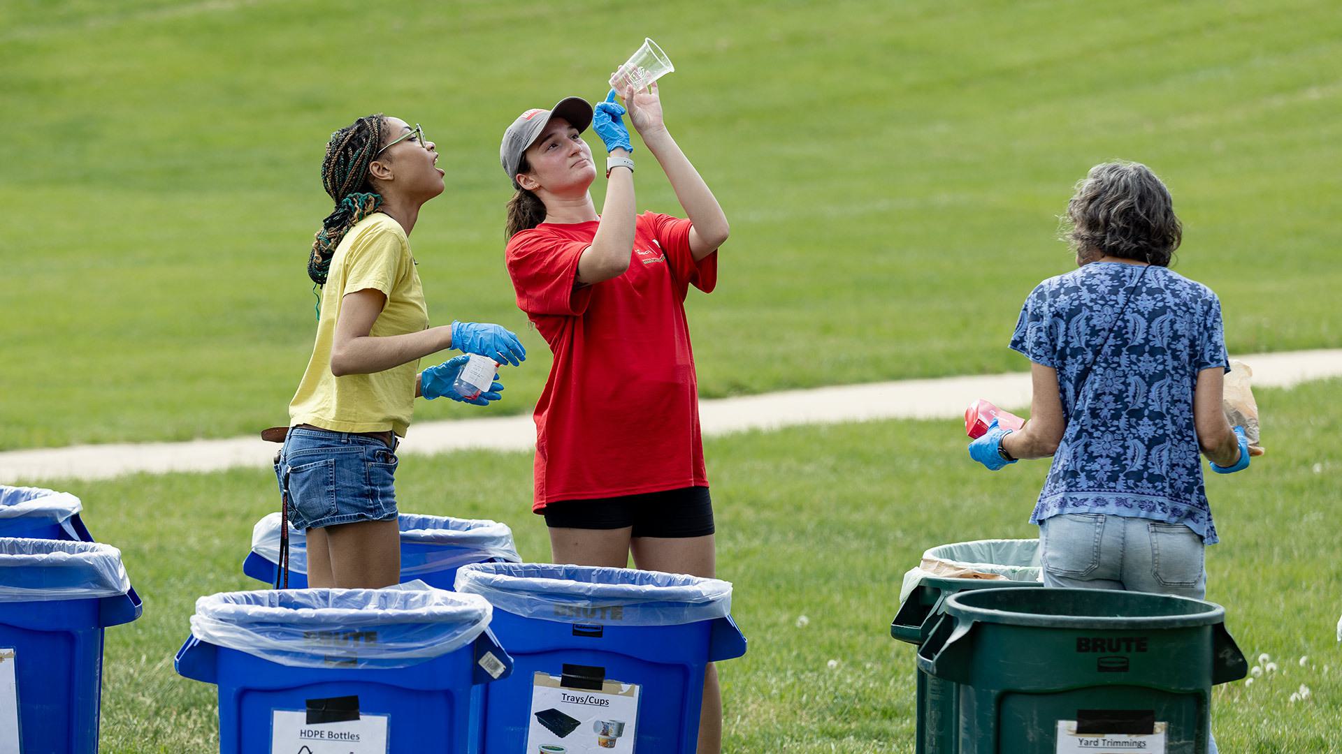 two students examine trash