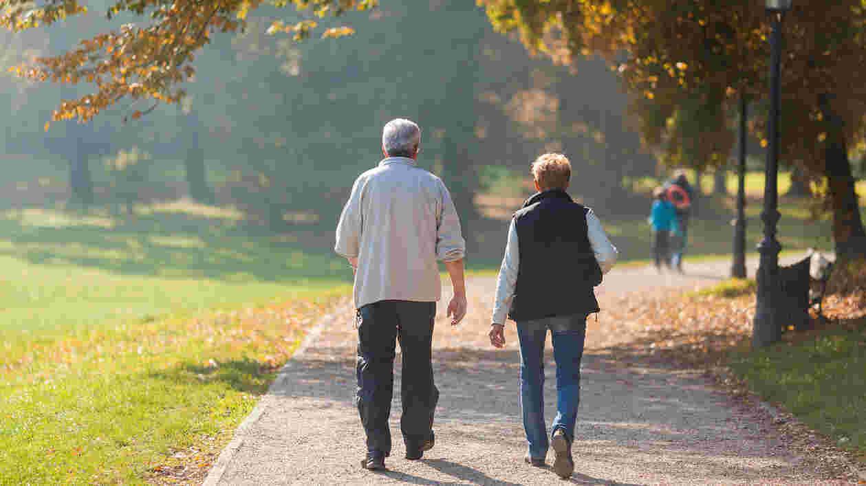 older couple walks down path in park