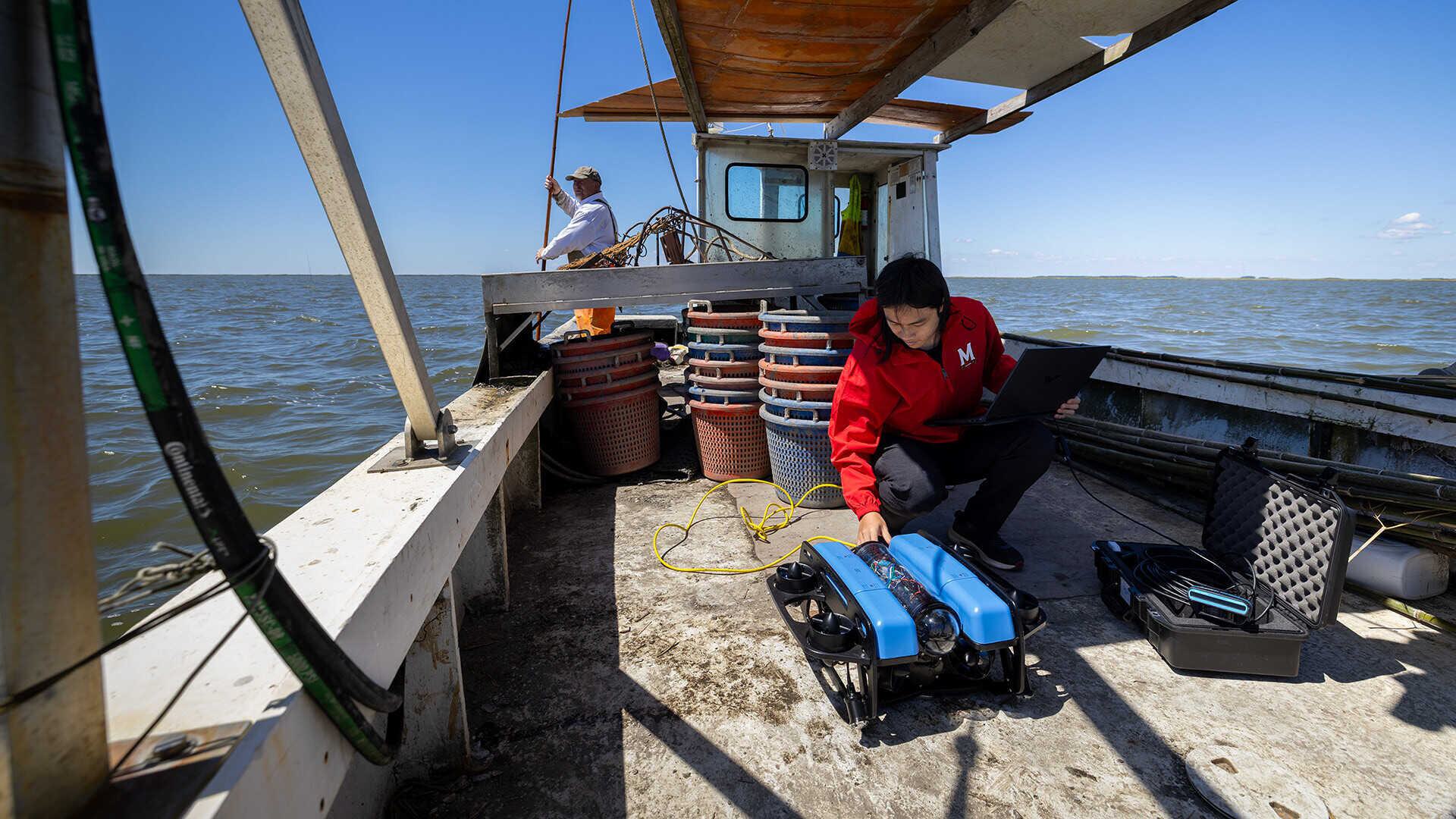 Man on a boat gets ready to launch an underwater robot