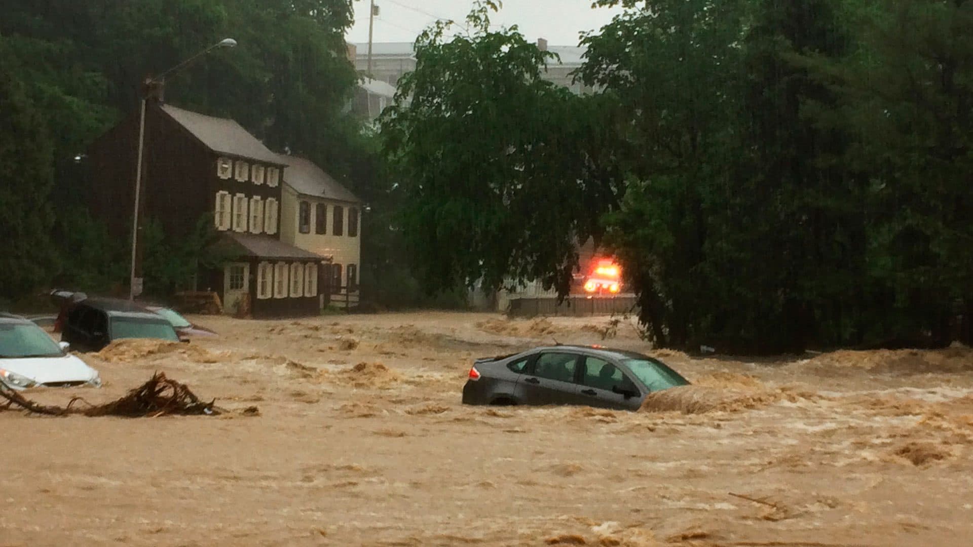 Water rushes through Main Street in Ellicott City, Md.