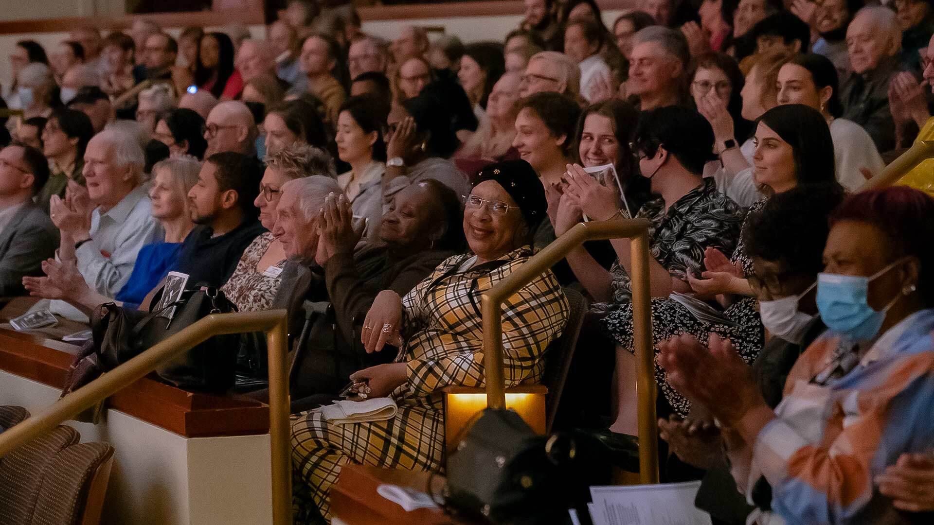 People sit happily in audience at a concert