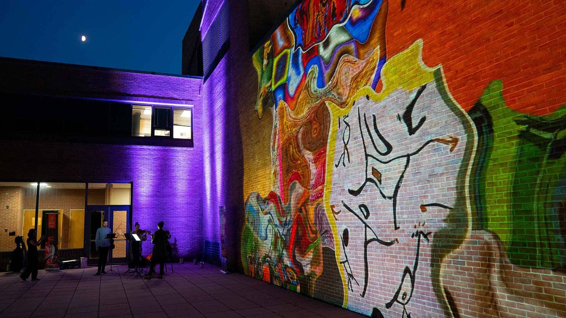 String quartet plays outside as artwork is projected onto building's walls