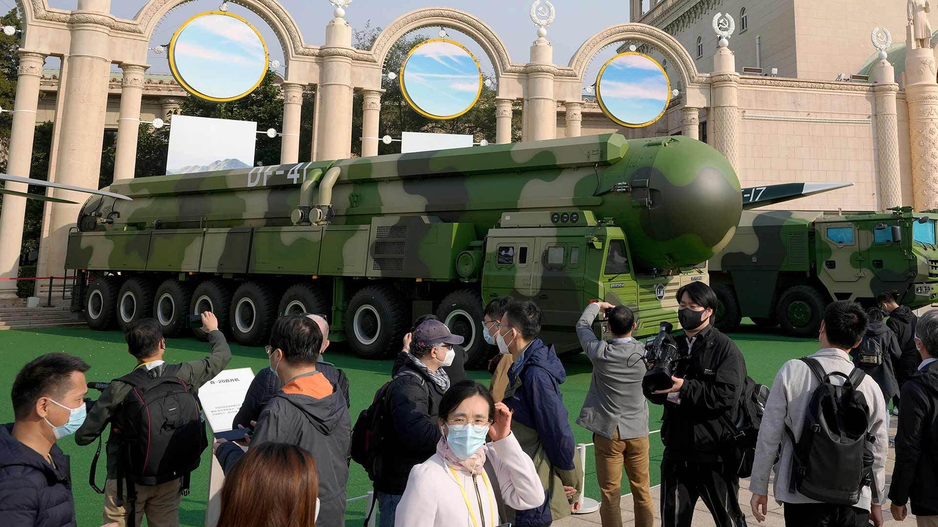 People look at a nuclear warhead painted in camoflauge