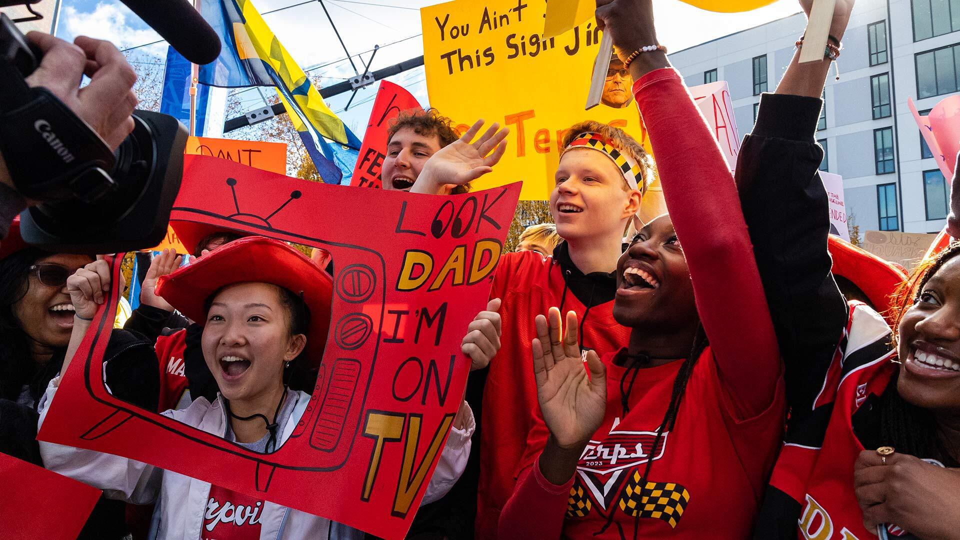 students display hand made signs and cheer