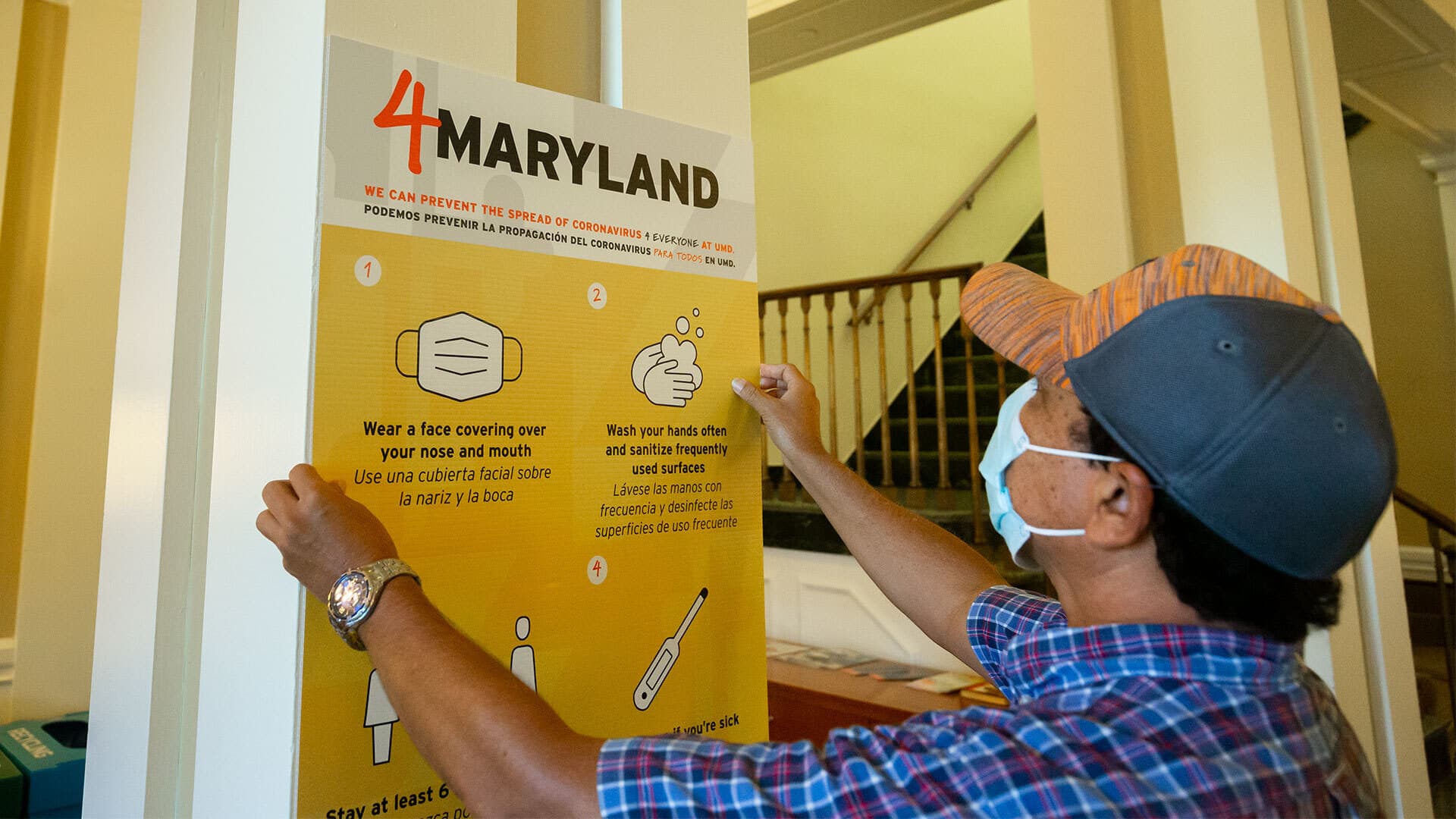 Masked employee hanging up "4 Maryland" poster