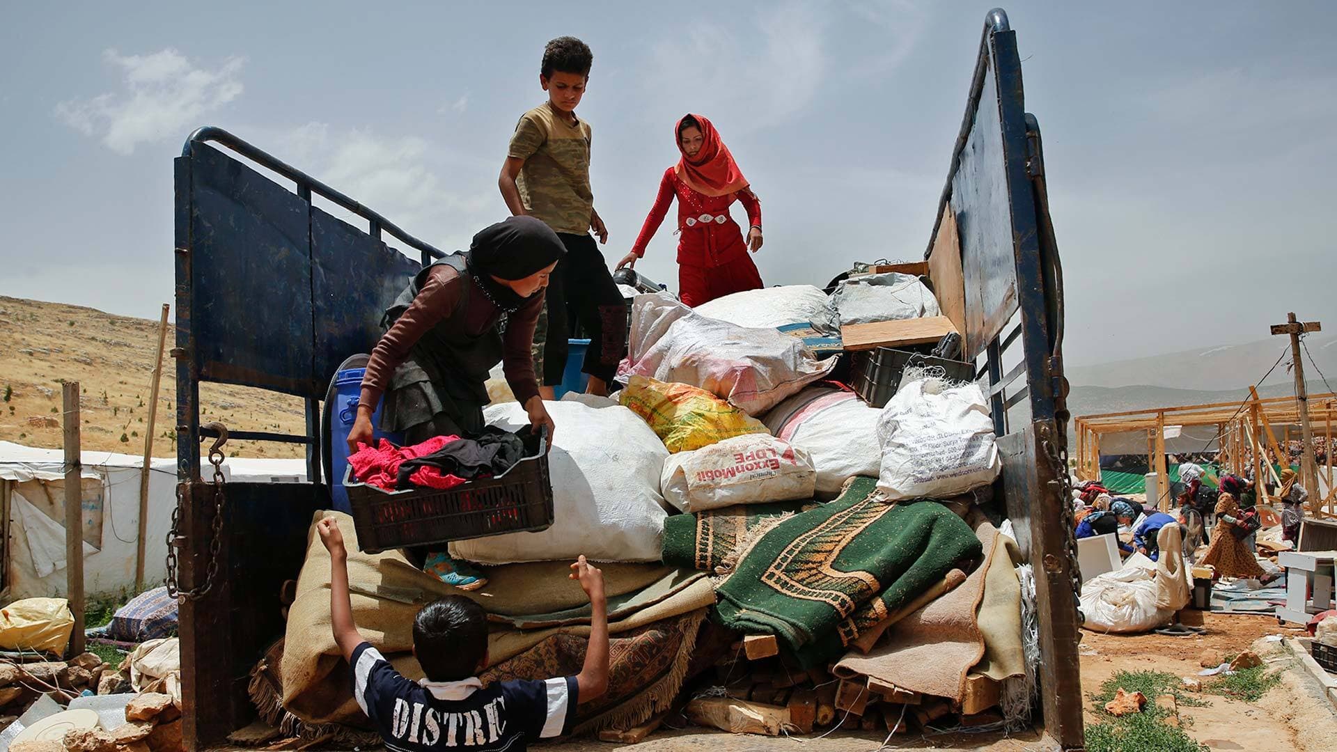 Syrian family loads belongings onto pickup
