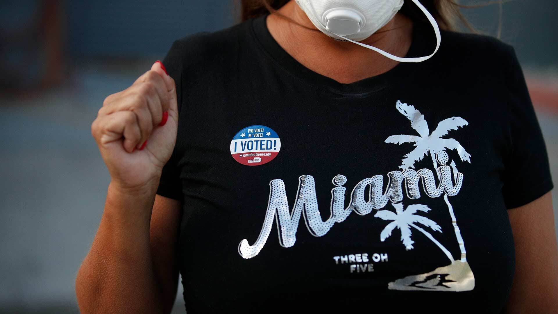 Person wearing Miami T-shirt and "I voted" sticker