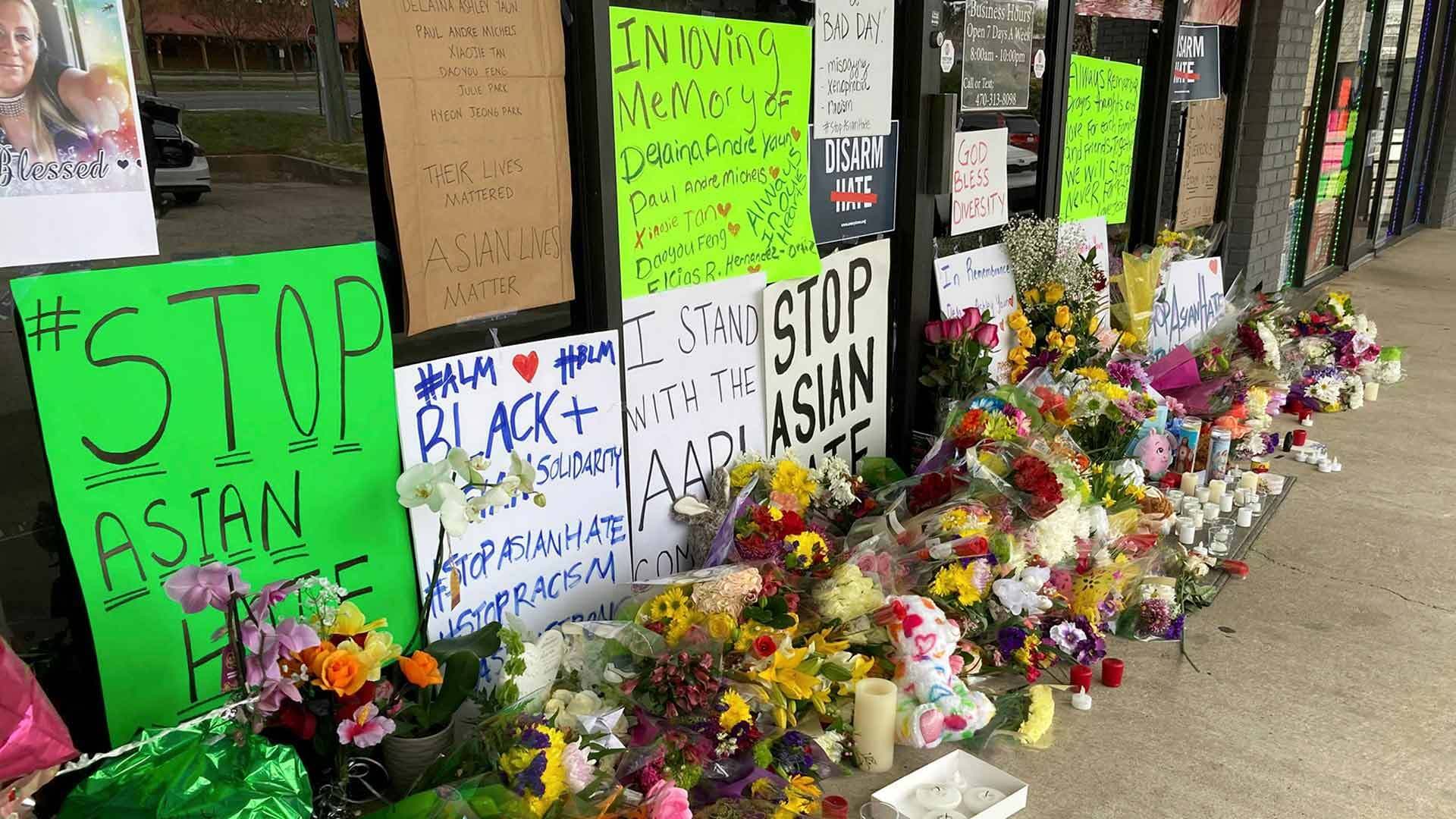 Memorial with flowers and "Stop Asian hate" signs