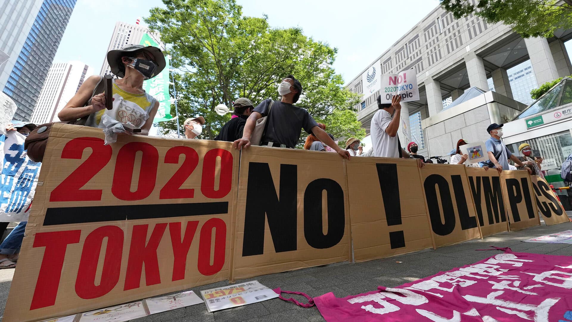 People gather near the venue of the Tokyo Olympic flame arrival ceremony in the Japanese capital on July 23, 2021, calling for the cancellation of the Summer Olympics.
