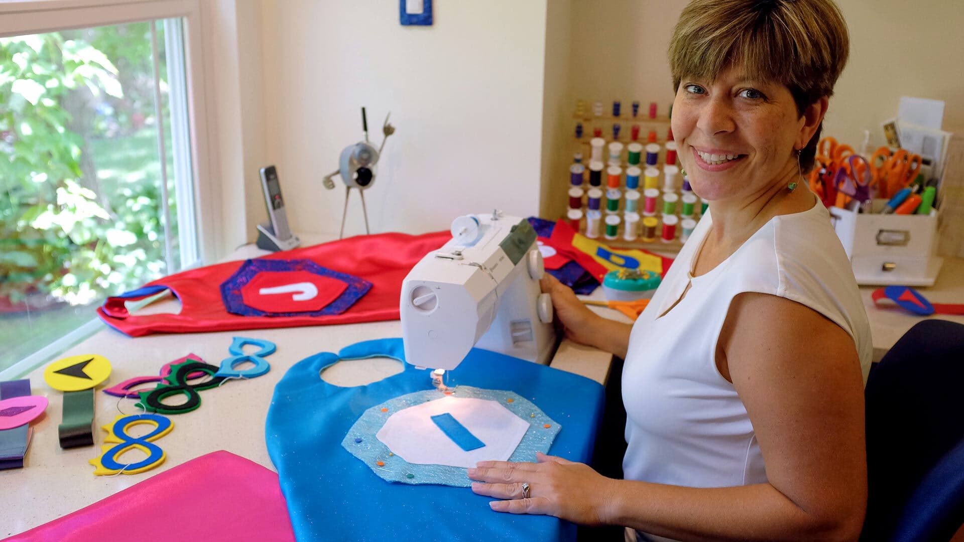 Holly Hagen ’89 makes capes at sewing machine