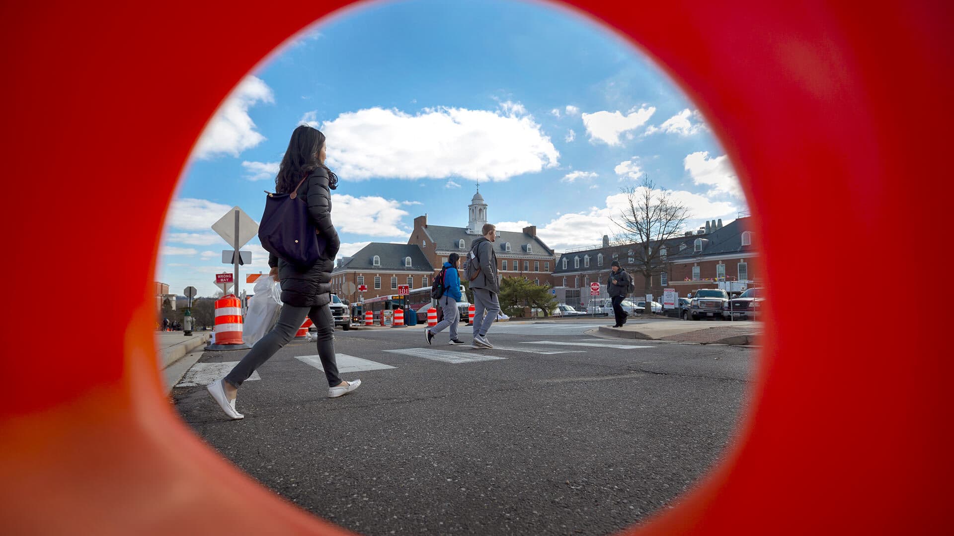 Students walk amid orange construction cones on Campus Drive