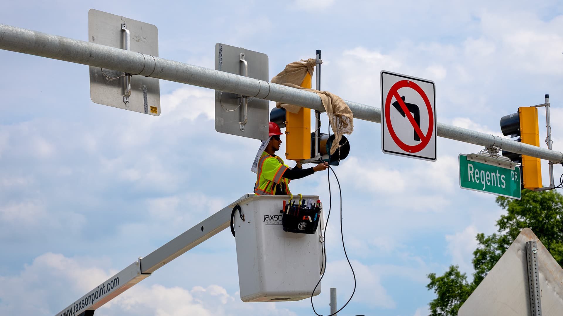 construction worker works on stoplight