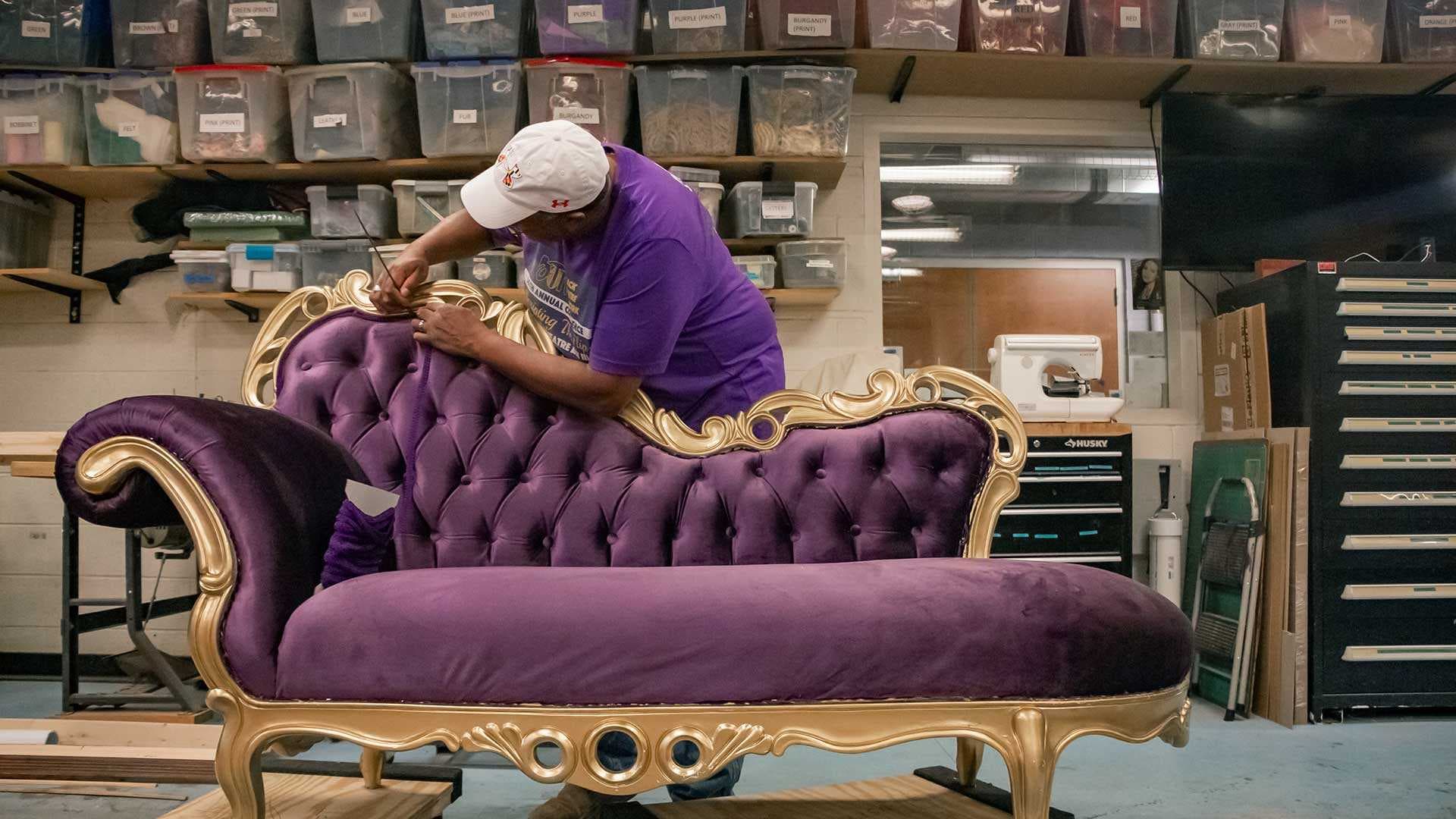 Clarice staff member places trim on purple couch