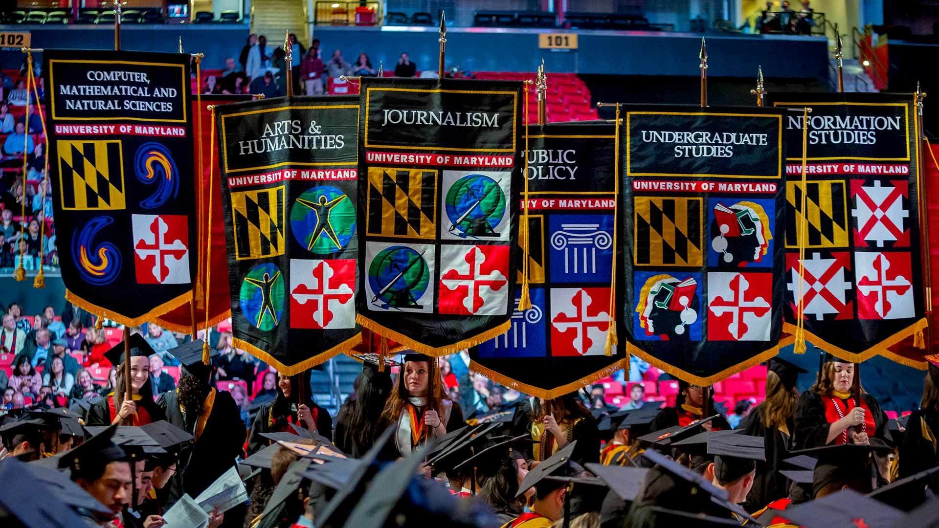 Senior marshals carry banners into commencement
