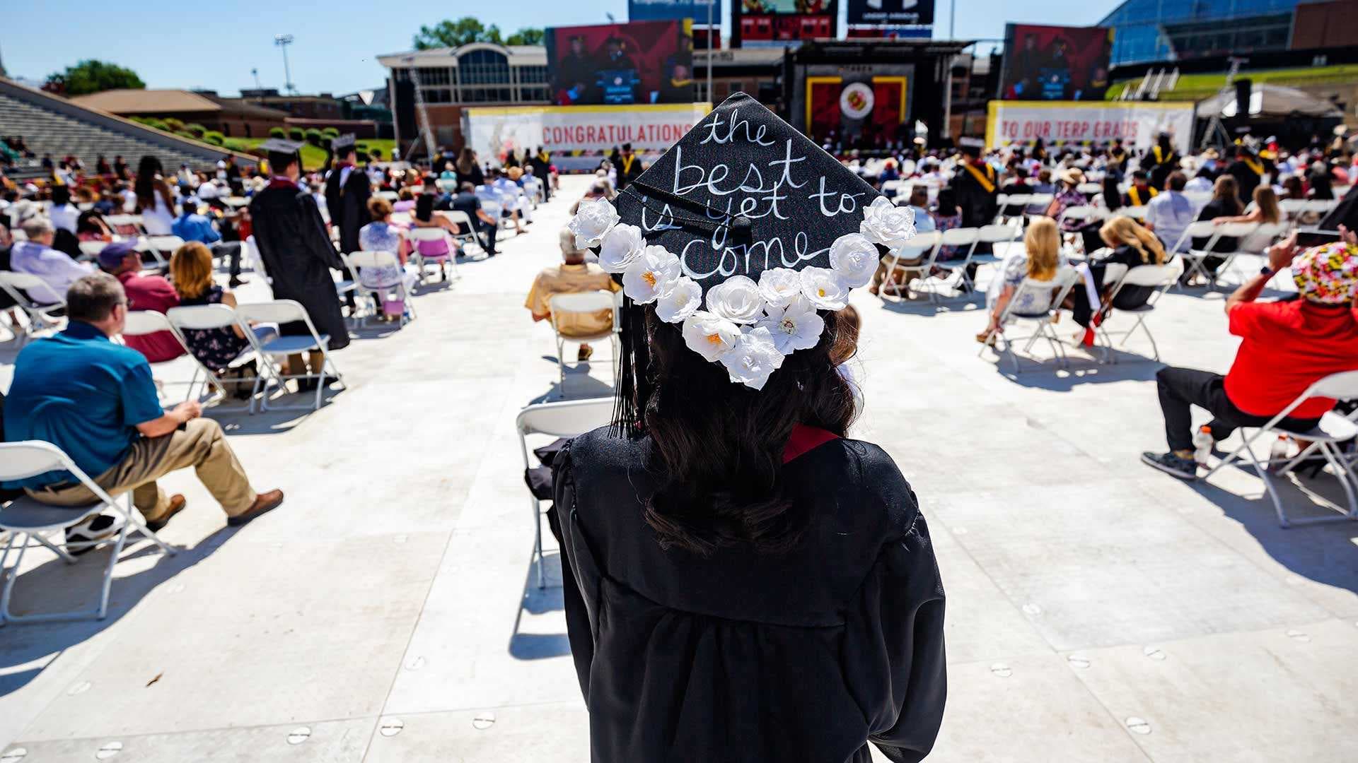 Student at commencement with cap that says, "The best is yet to come"