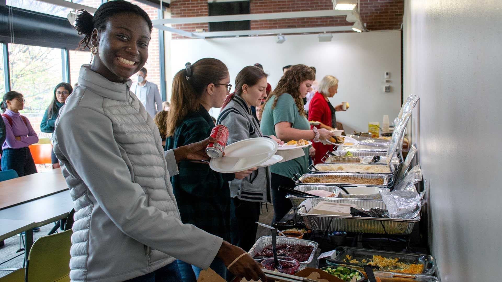 students fill plates at Thanksgiving gathering