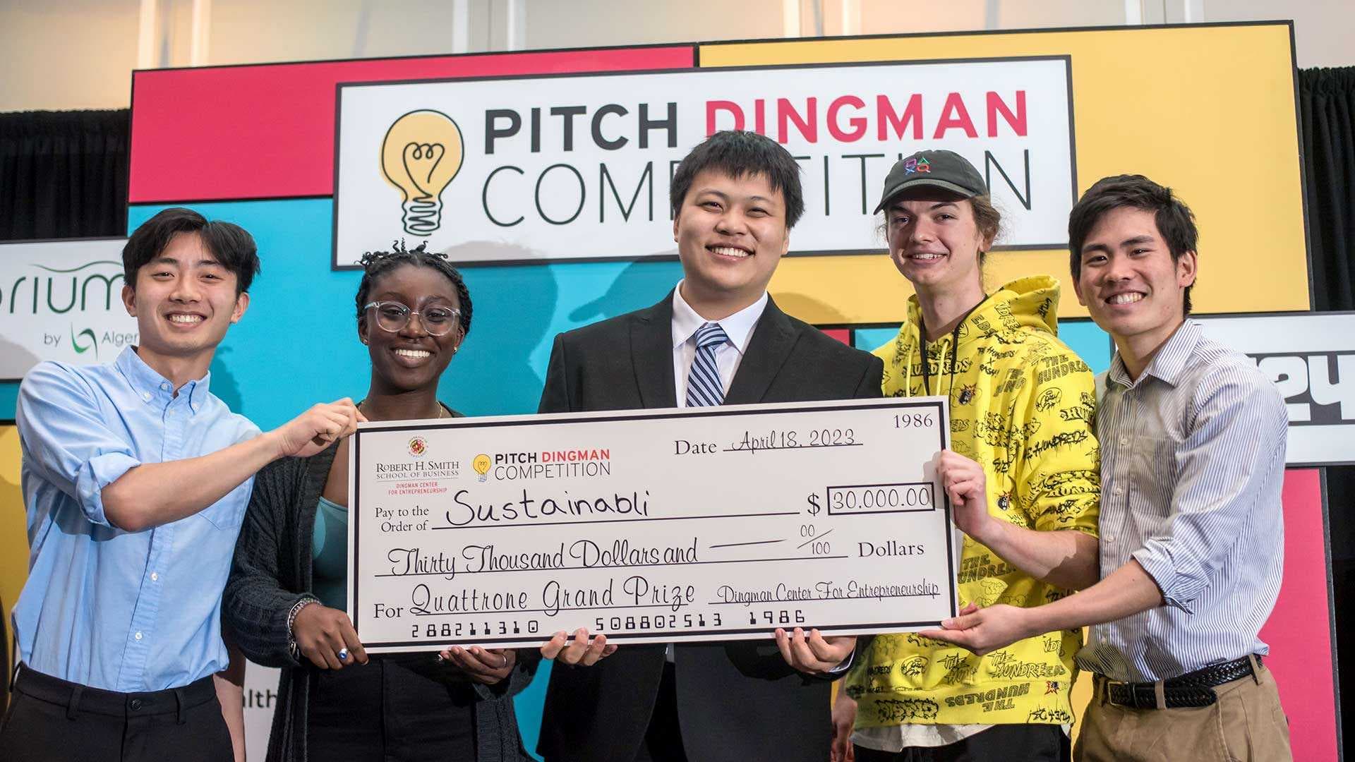Students hold up big check made out to Sustainabli at Pitch Dingman competition