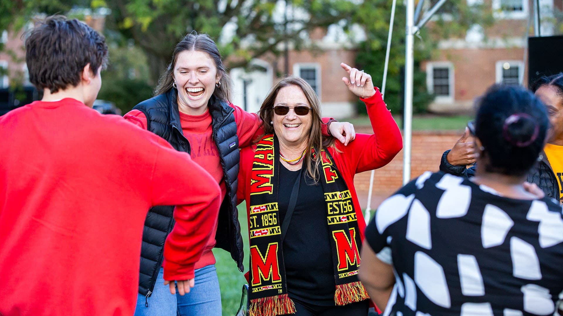 Student, mom, sister dance together at family weekend on mckeldin mall with big smiles