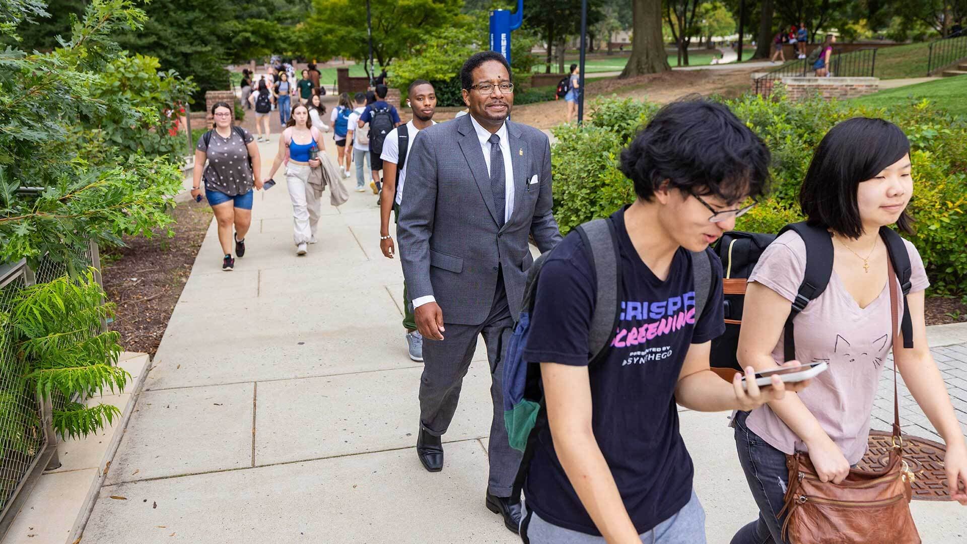 Pines walks with students on campus