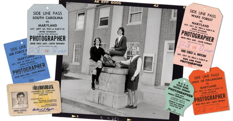 Black and white photo of three UMD cheerleaders posing with the Testudo statue, plus Dick Byer's press passes