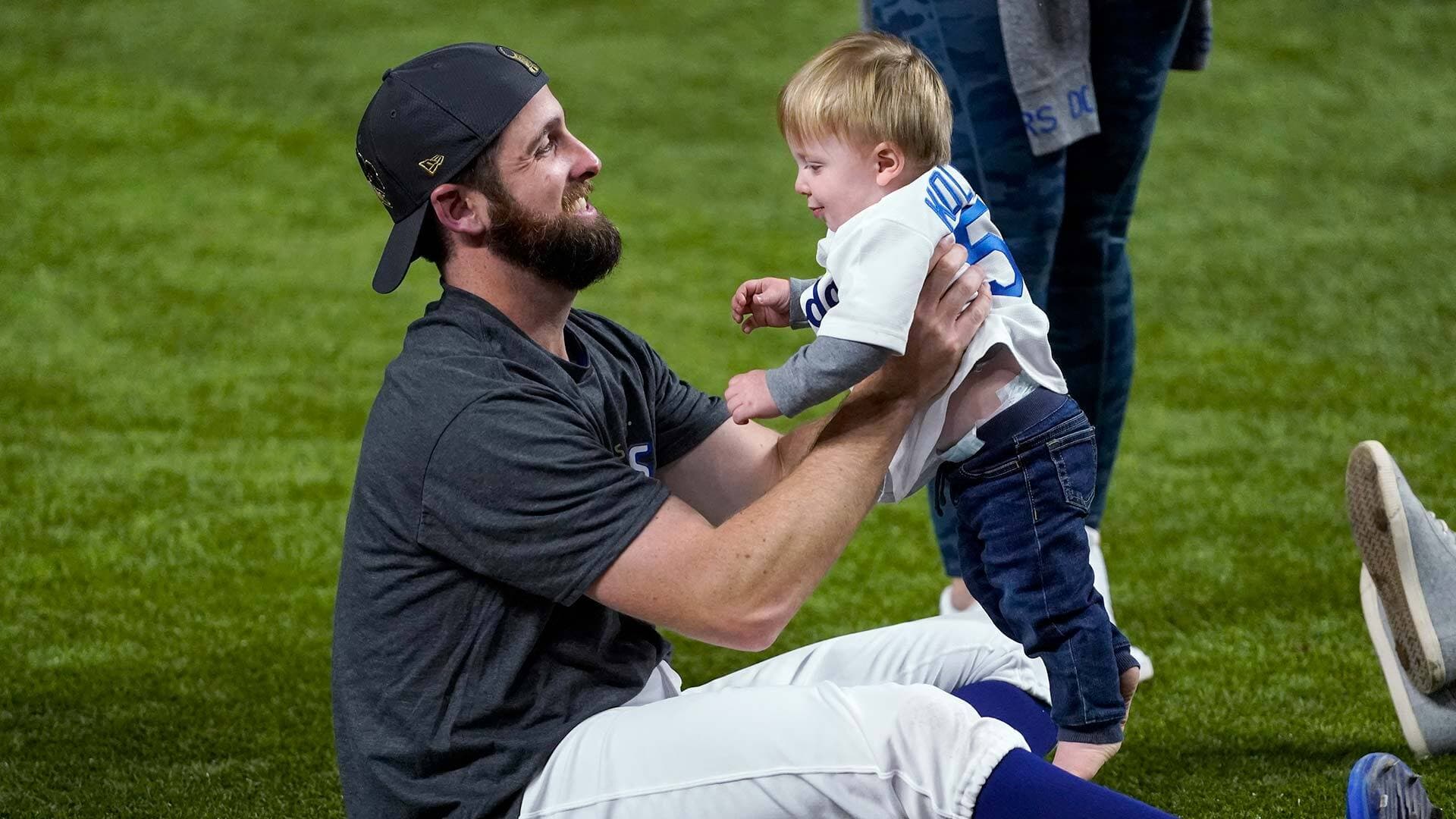 Adam Kolarek celebrates on field with son
