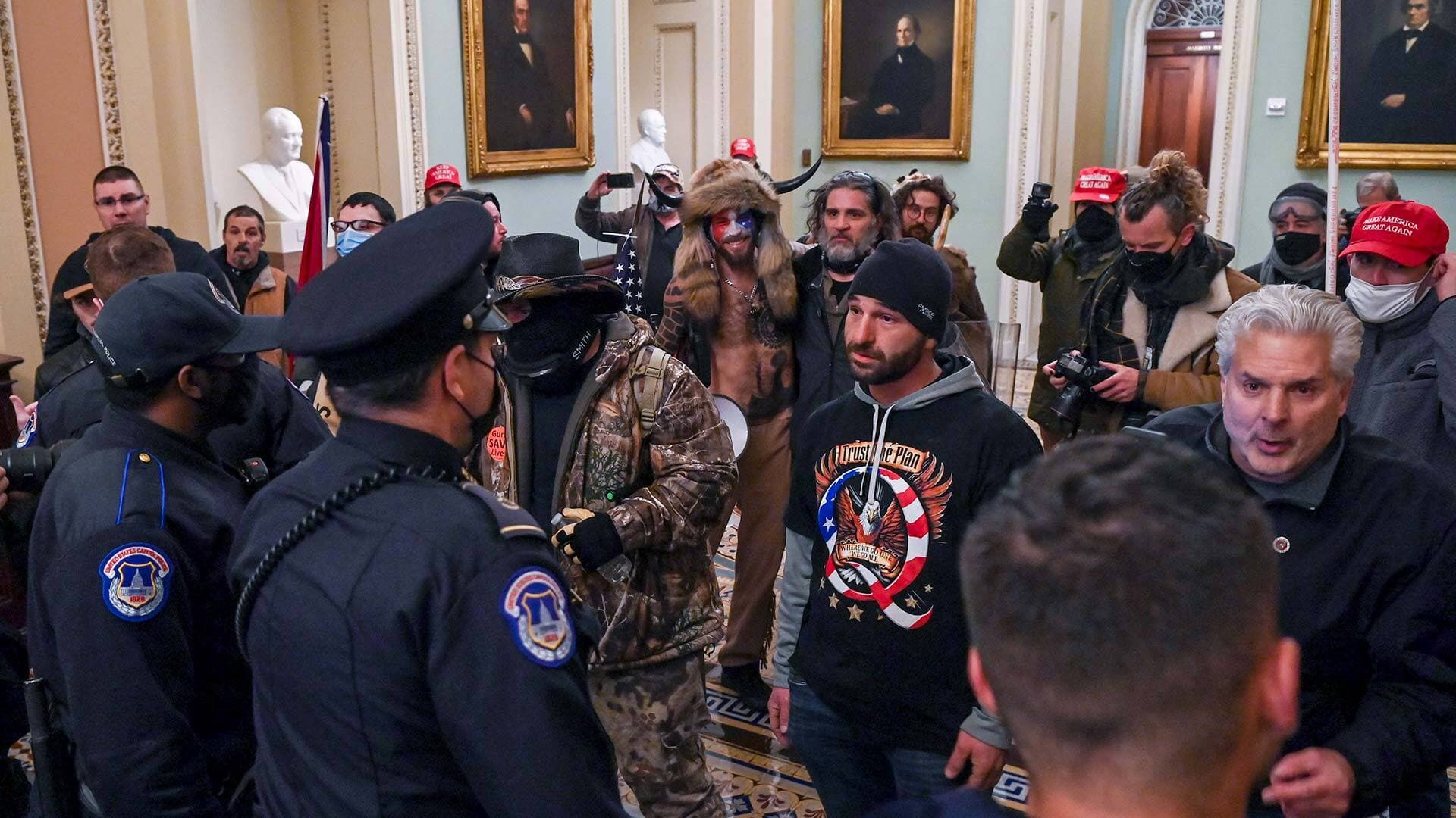 A man wearing a QAnon sweatshirt protests against US Capitol police officers