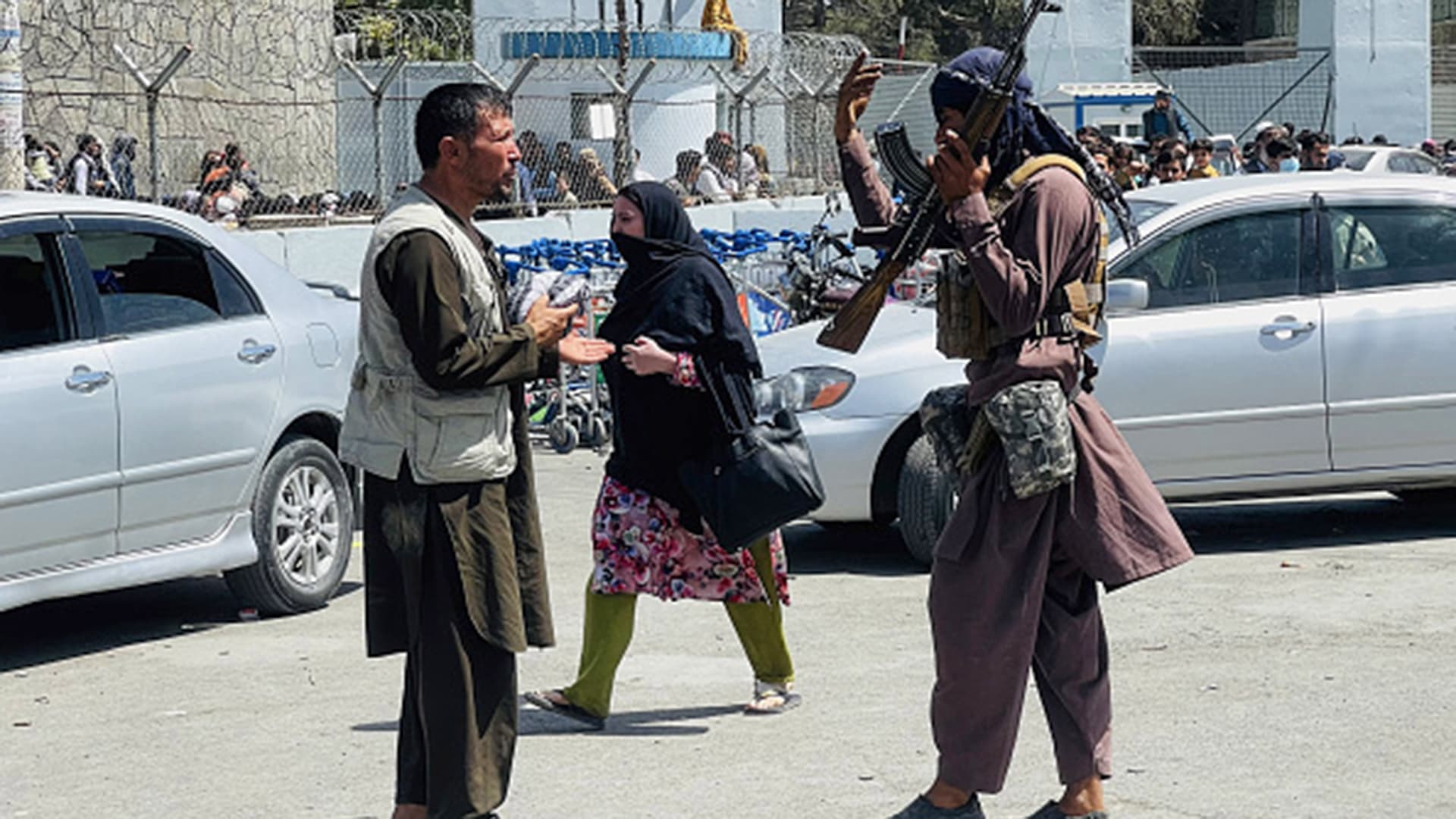 Taliban members stand near Kabul airport as Afghans rush to flee