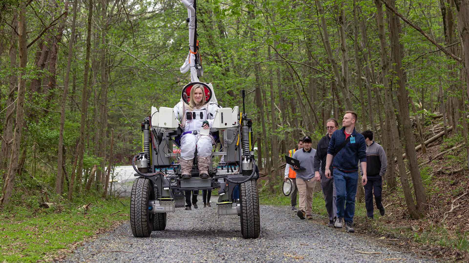 Maggie Haslam wears space suit while riding lunar rover