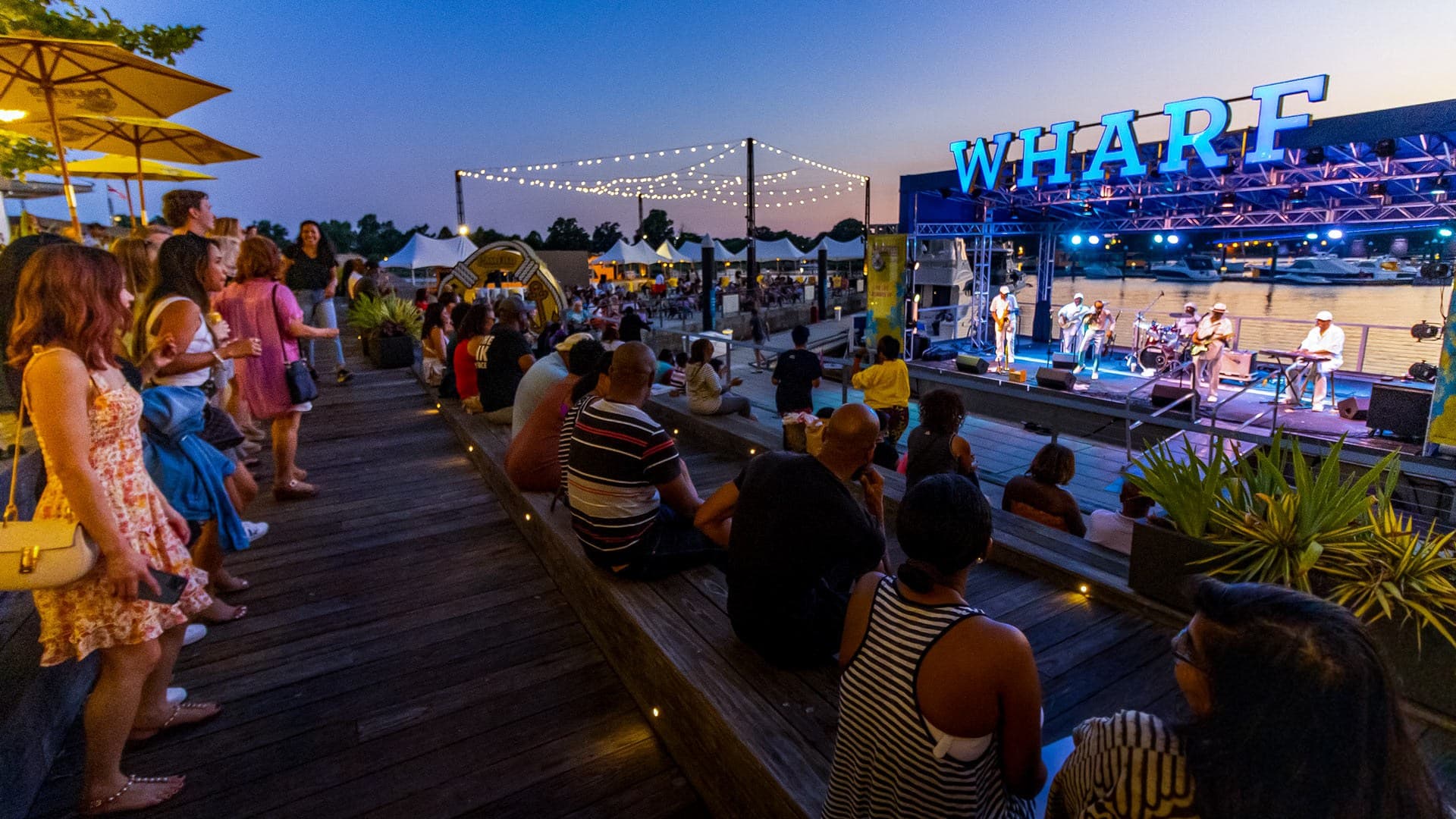 crowd watches outdoor concert at the Wharf