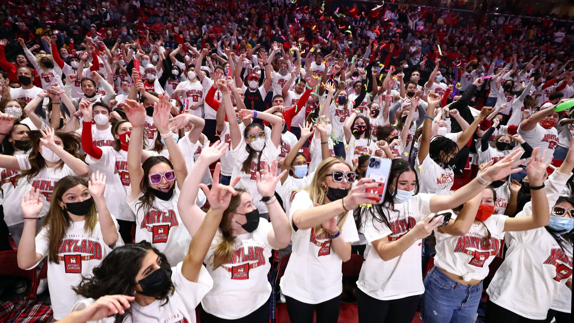 UMD students wearing matching white T-shirts dance in flash mob at basketball game