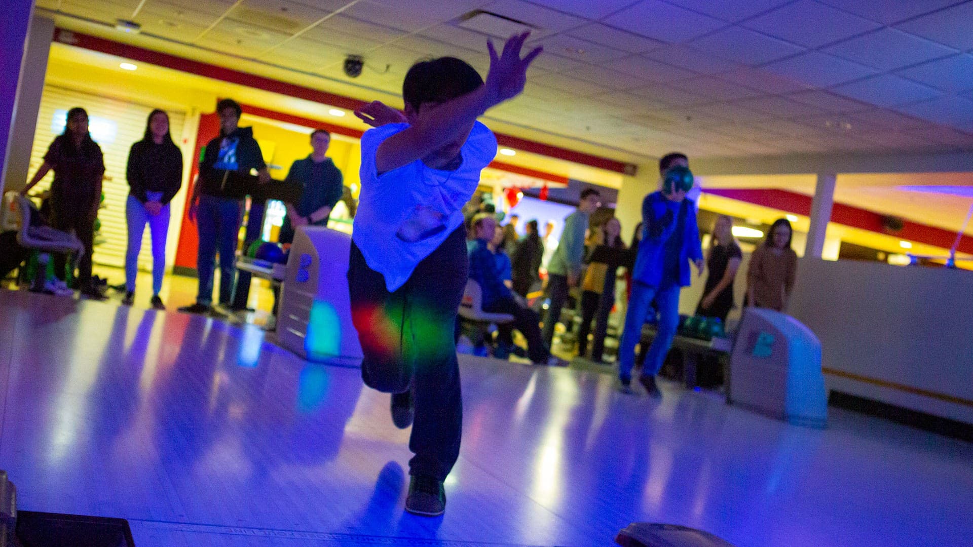 a bowler rolls the ball during a cosmic bowling event