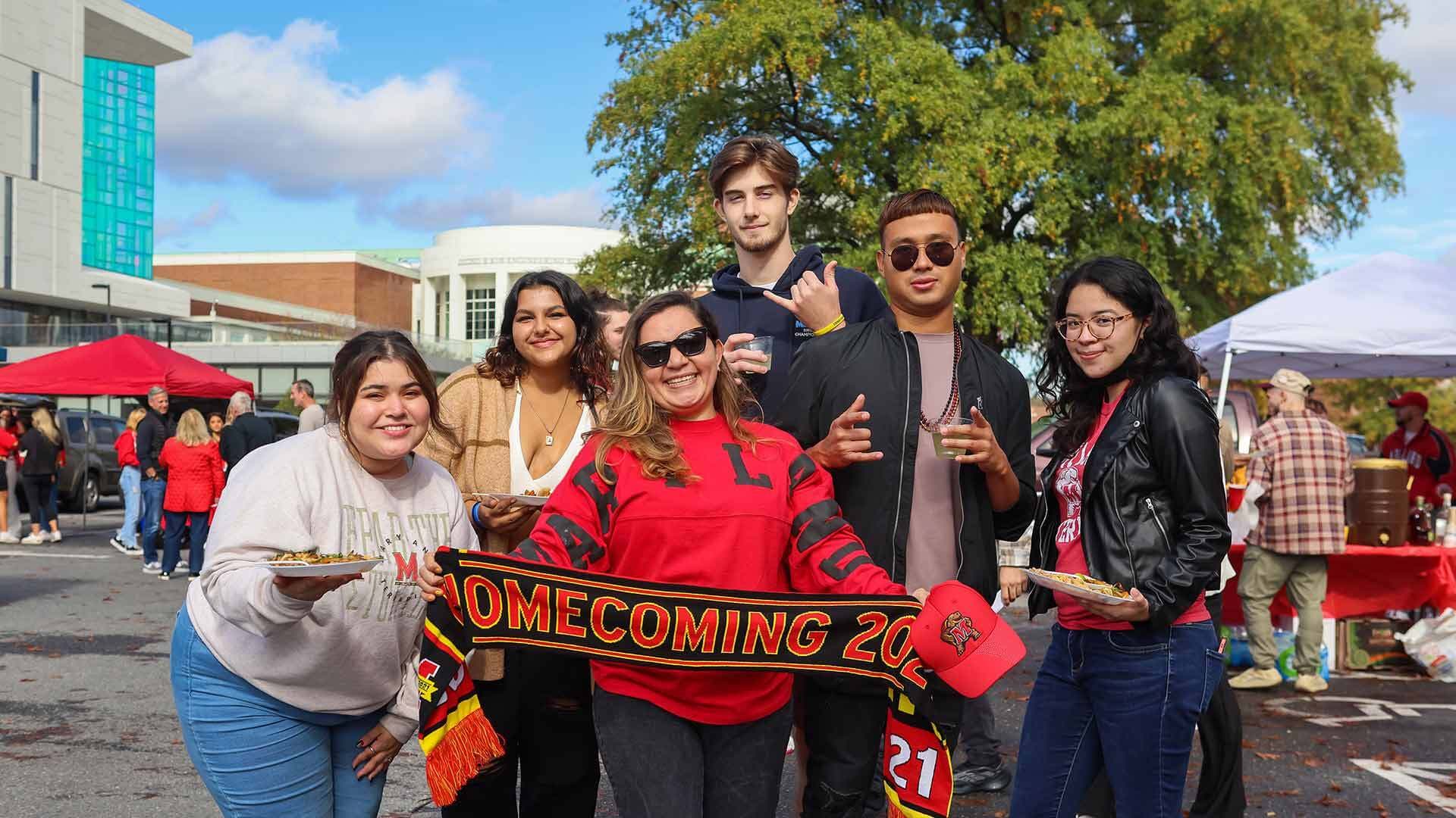 students celebrate homecoming and unfurl a homecoming scarf near the IDEA Factory building