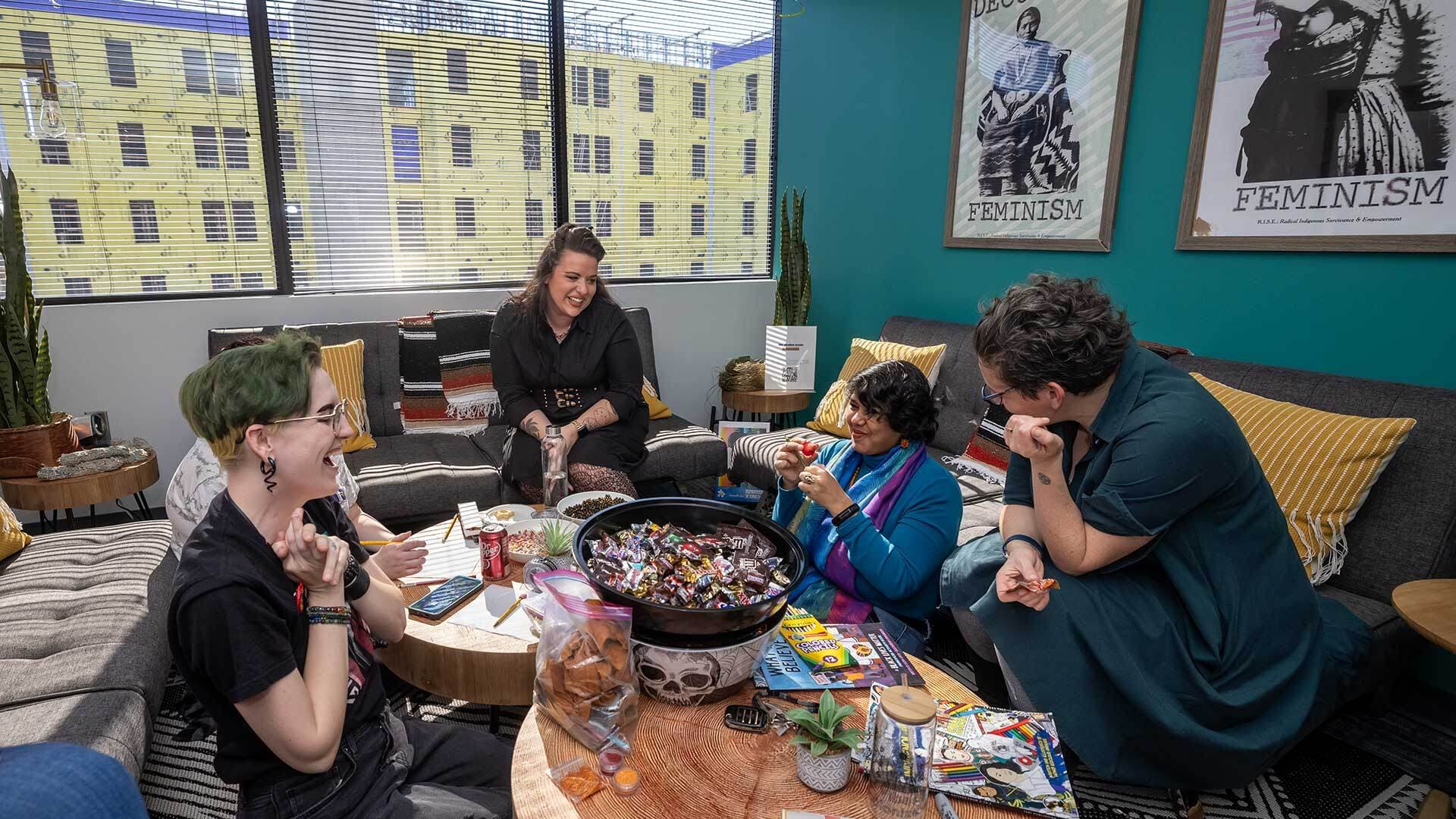 People gathered around wooden tables filled with candy