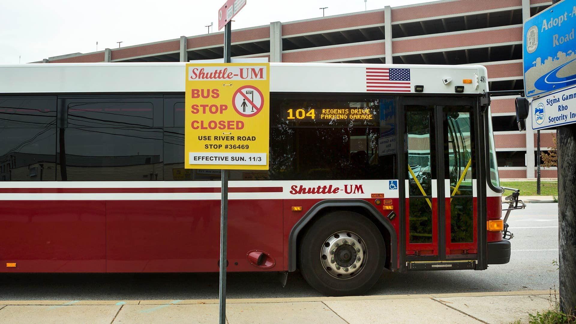 Yellow Shuttle-UM sign reading "Bus Stop Closed, Use River Road Stop #36469"