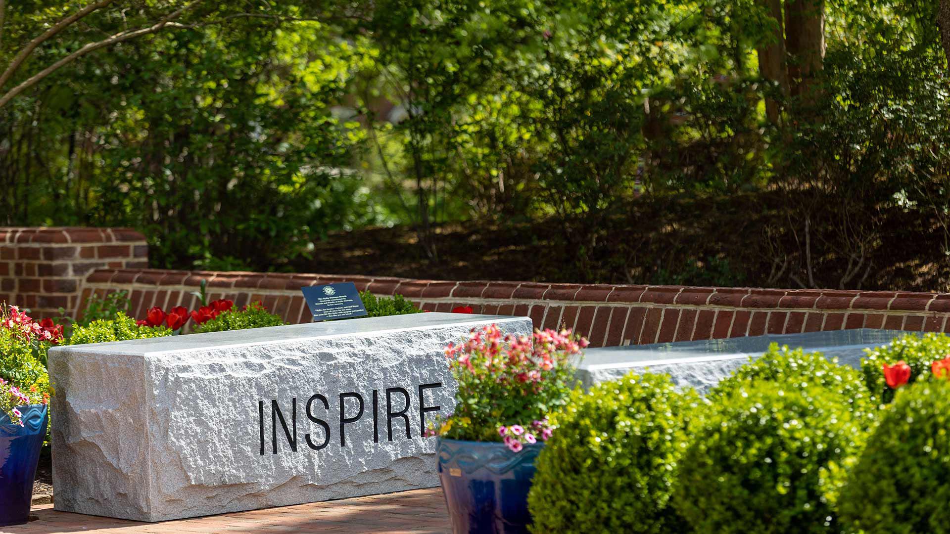"INSPIRE" written on granite bench