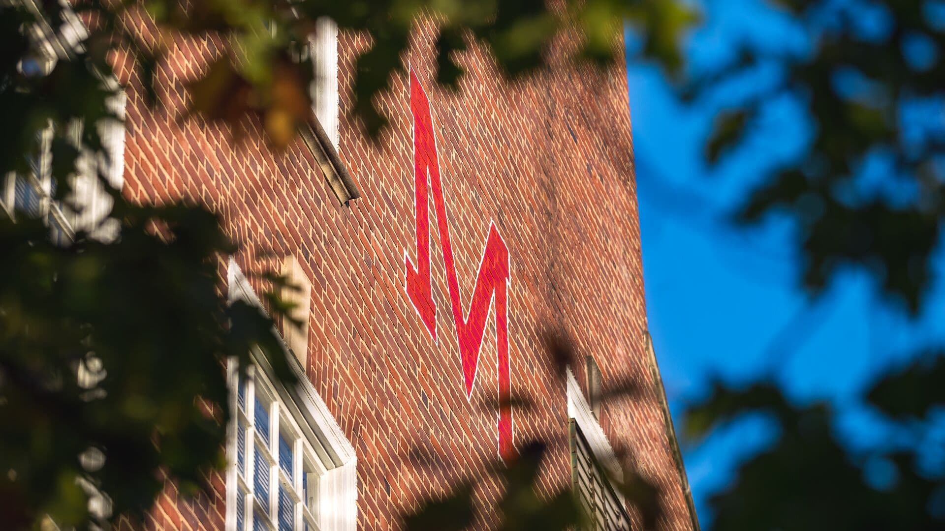 red M on the side of a brick campus building