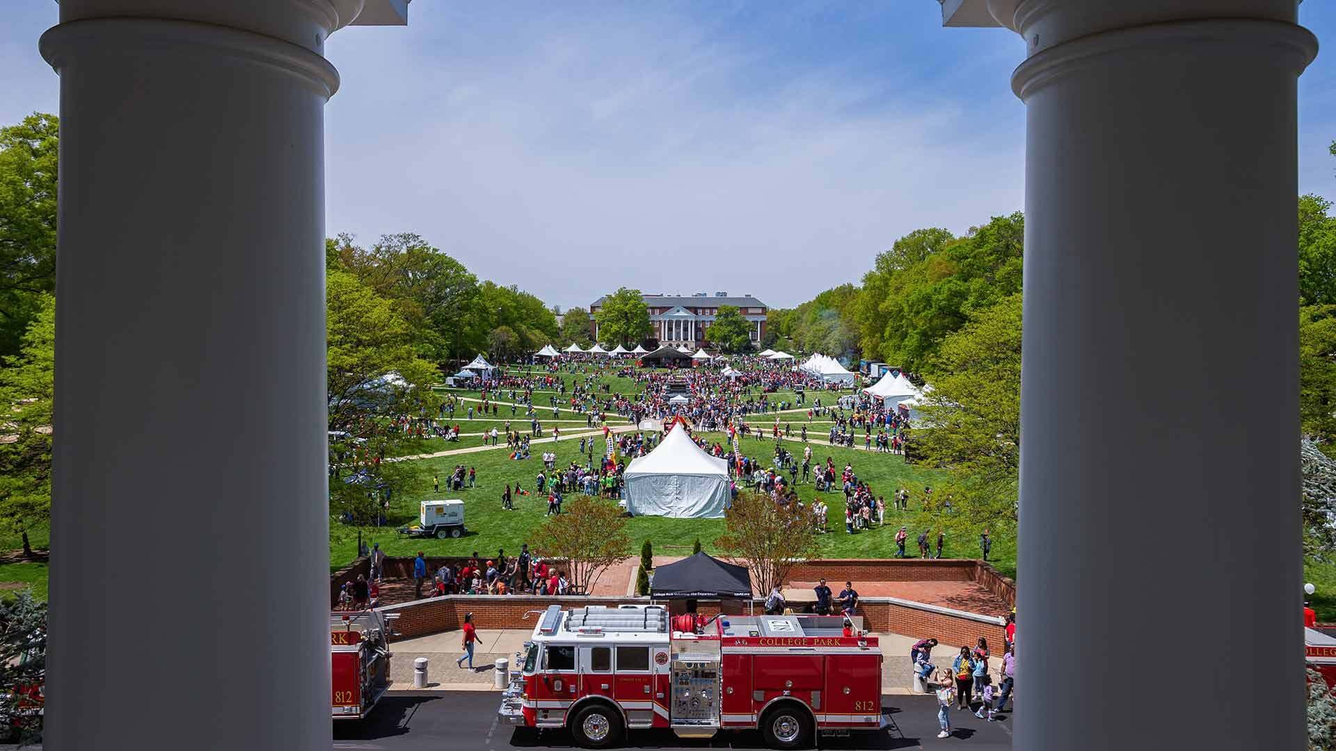 Firetruck with Maryland Day tents and crowd on McKeldin Mall in background