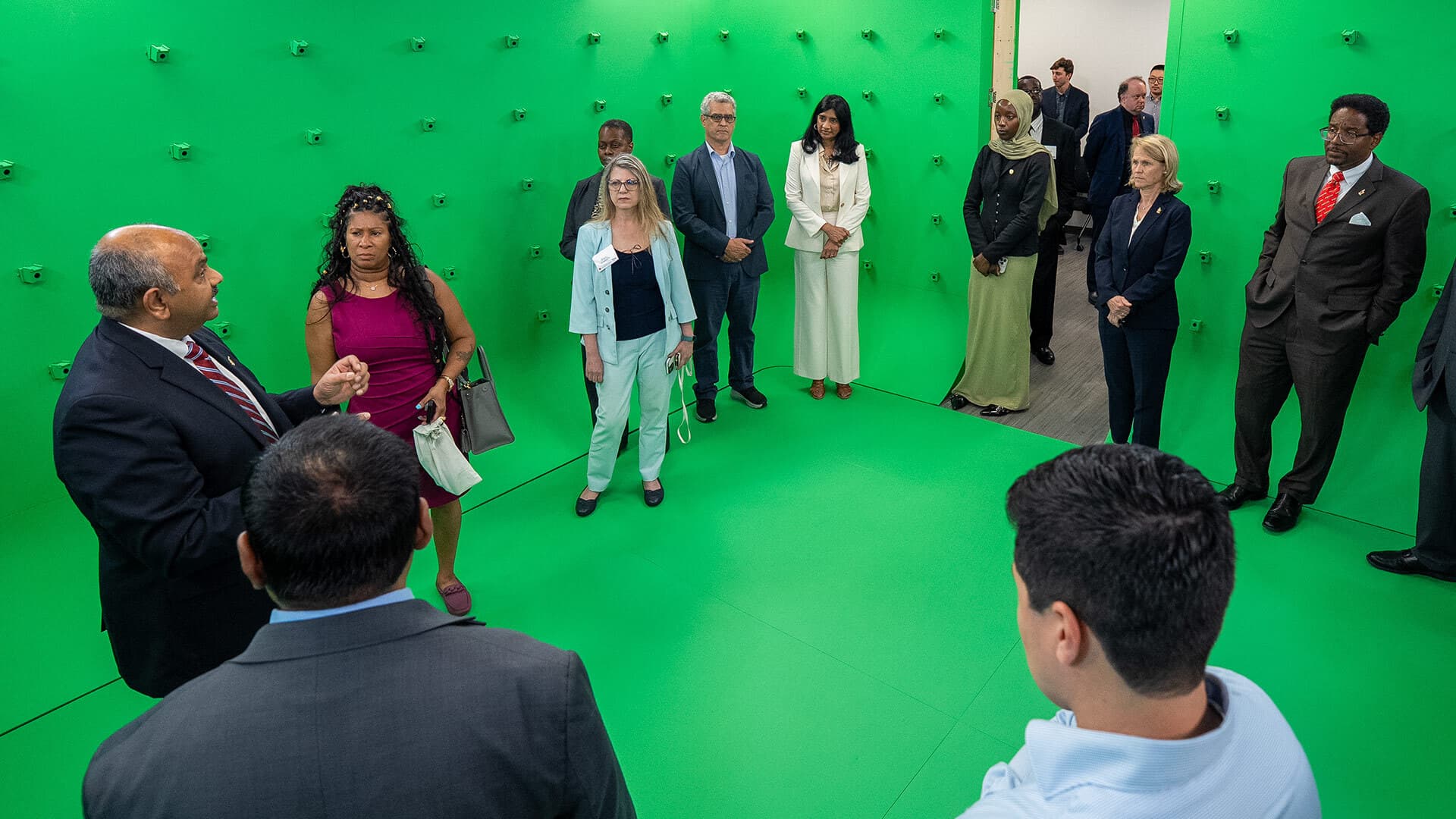 group stands in a circle in green room