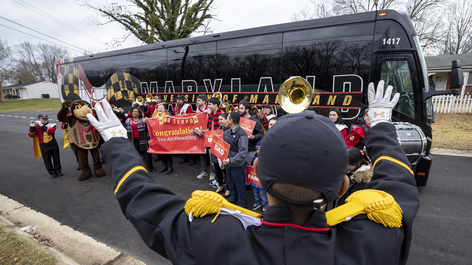UMD marching band plays outside bus as family celebrates