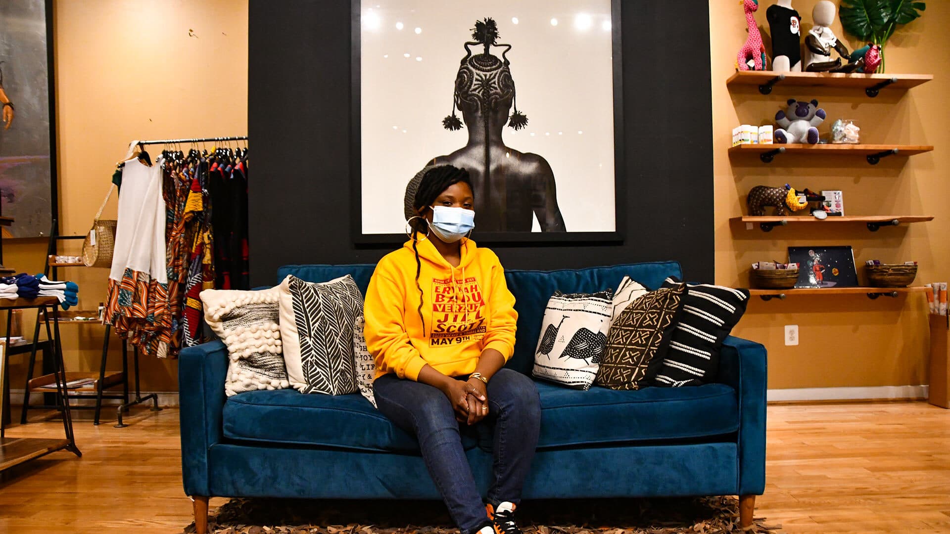 Anika Hobbs sits on couch in Nubian Hueman, a clothing and home décor boutique
