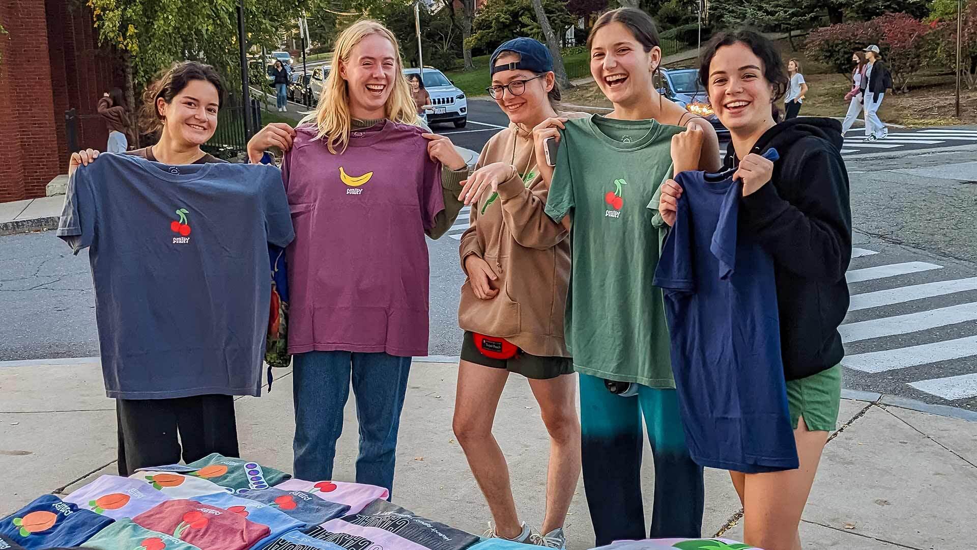 students holding shirts