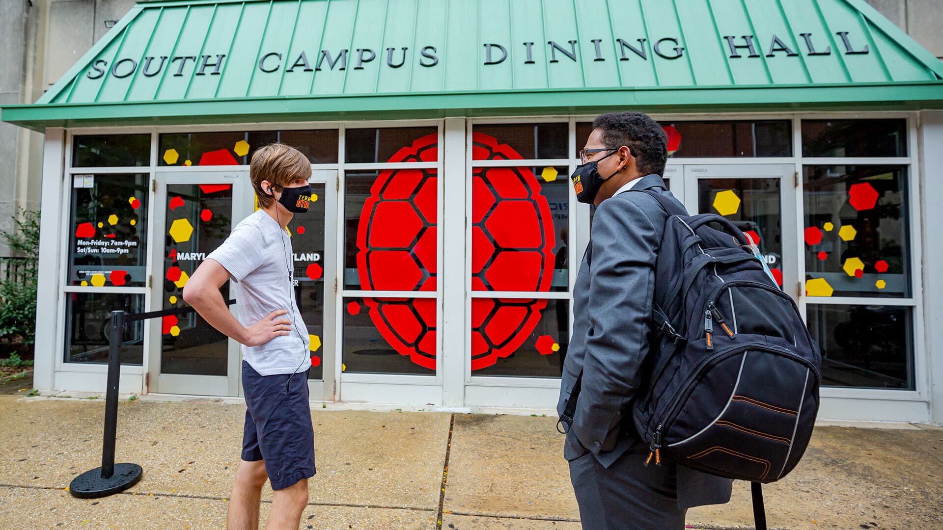 President Darryll J. Pines talks to a student outside South Campus Dining Hall