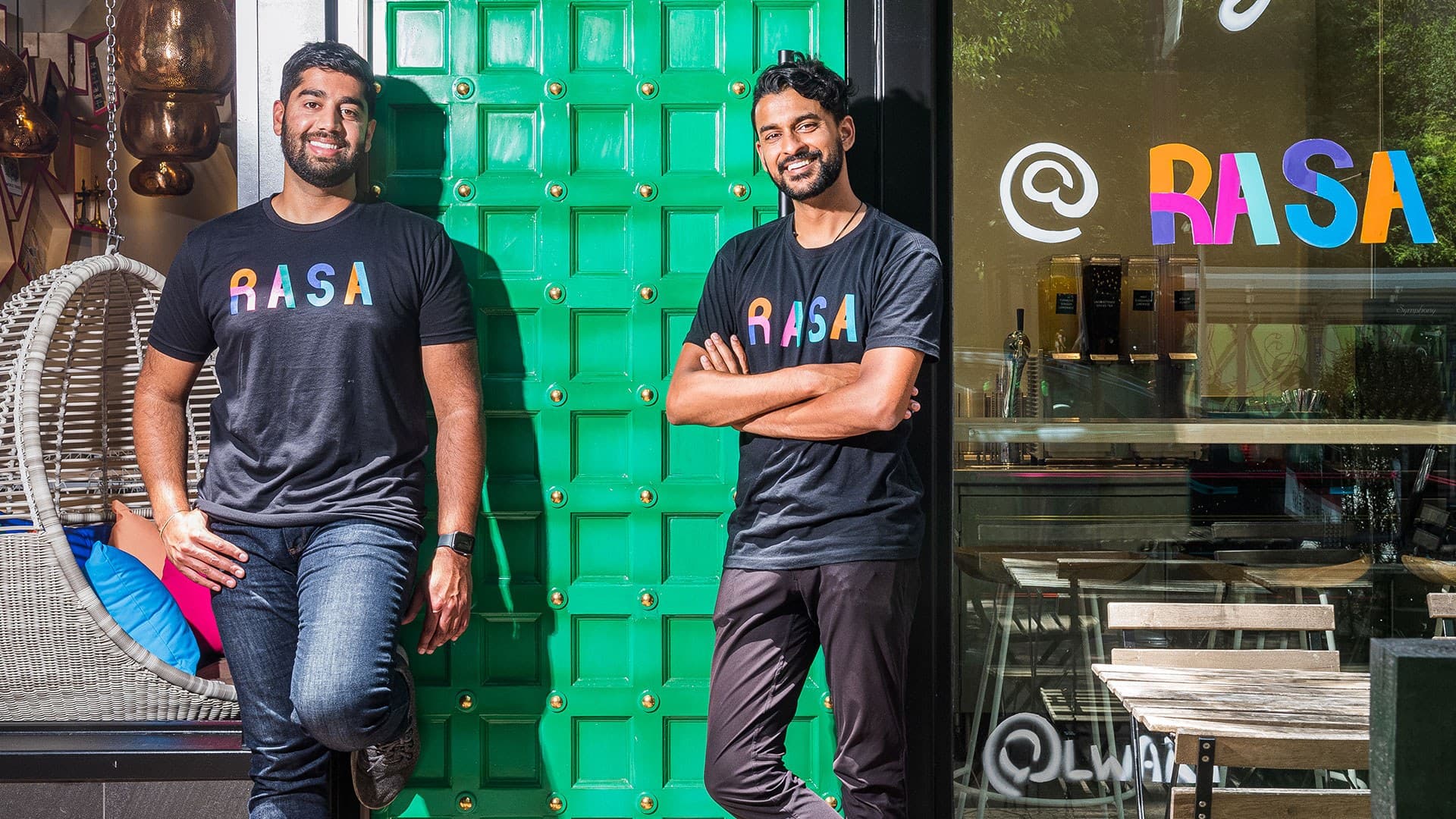 Rahul Vinod '11 and Sahil Rahman '12 pose outside Rasa restaurant with Rasa T-shirts