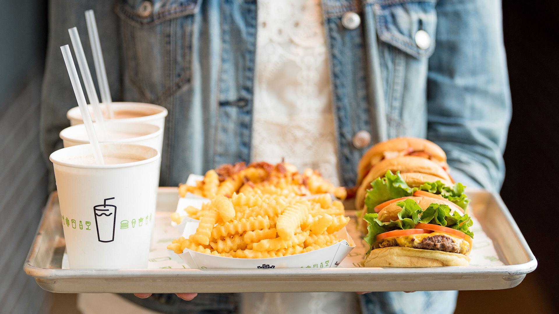 closeup of tray with milkshakes, fries and burgers from Shake Shack