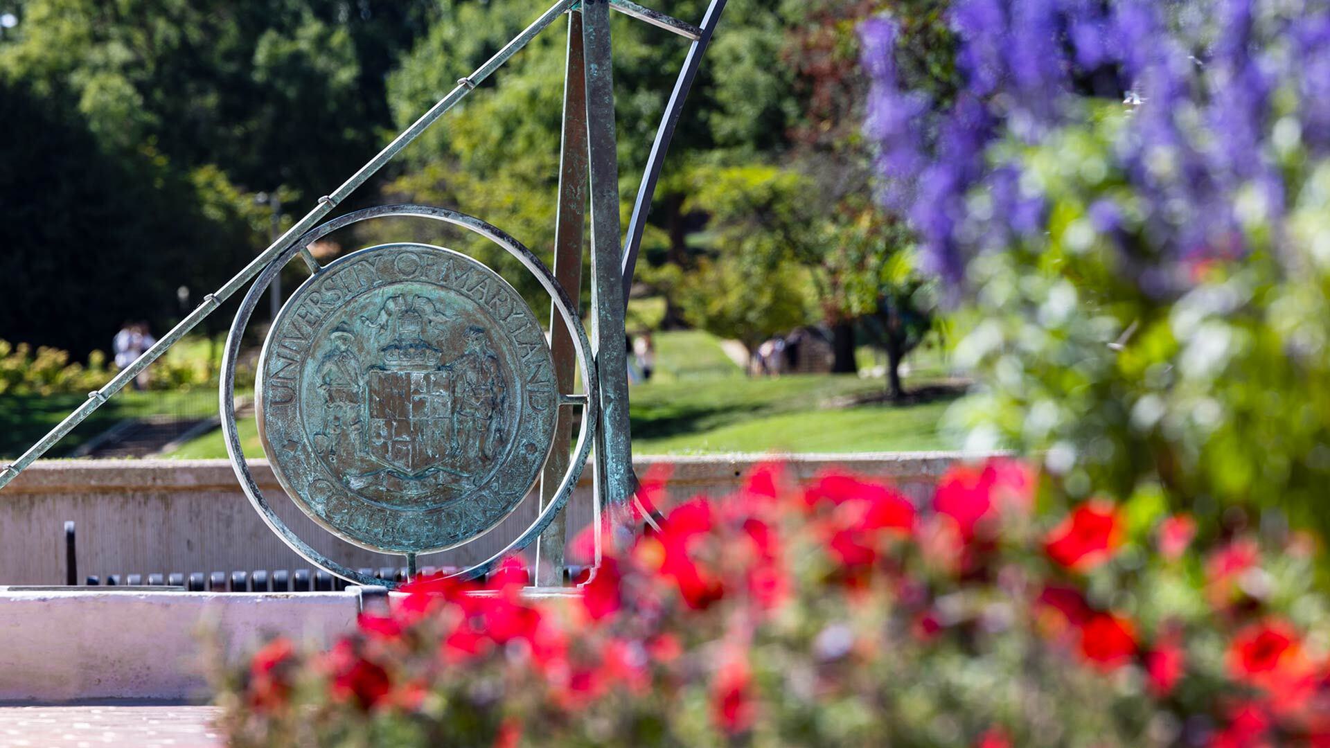 Sundial surrounded by red and purple flowers