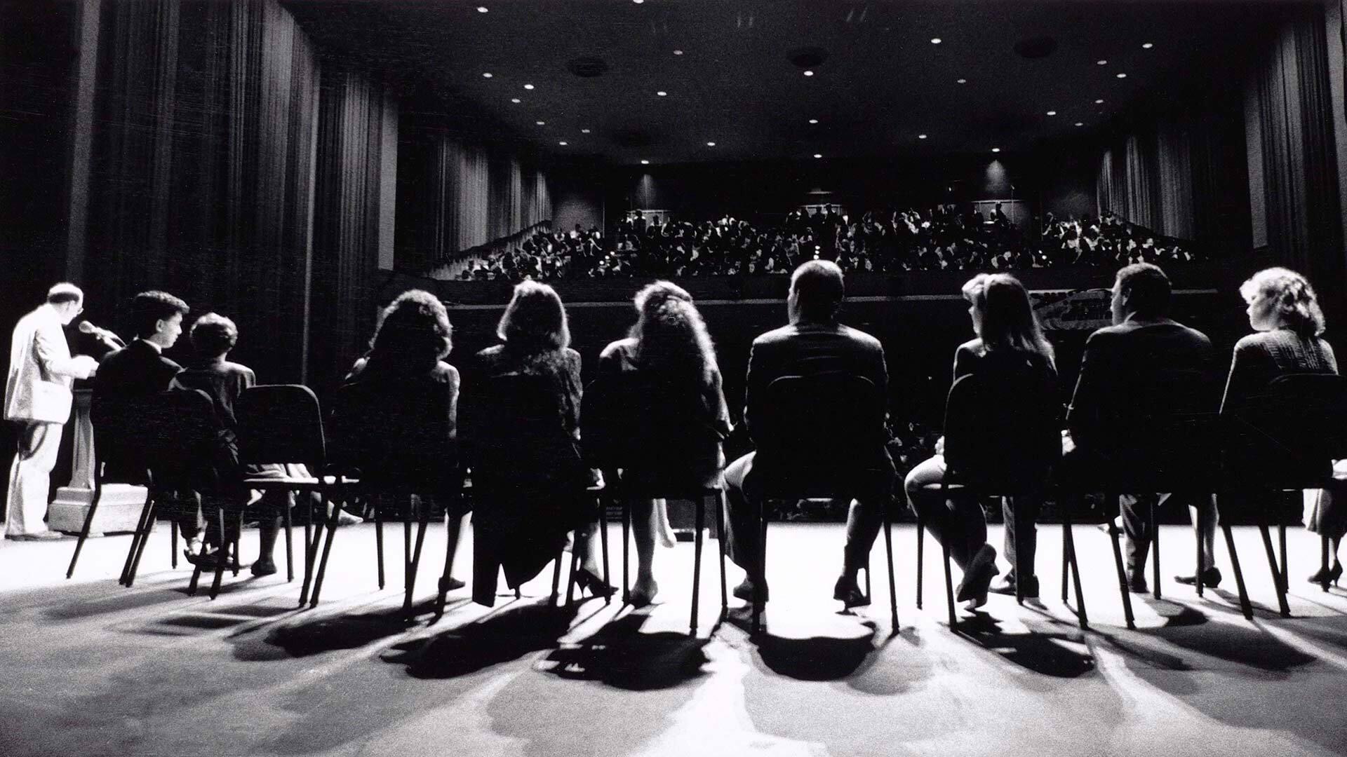 line of panelists sit on stage