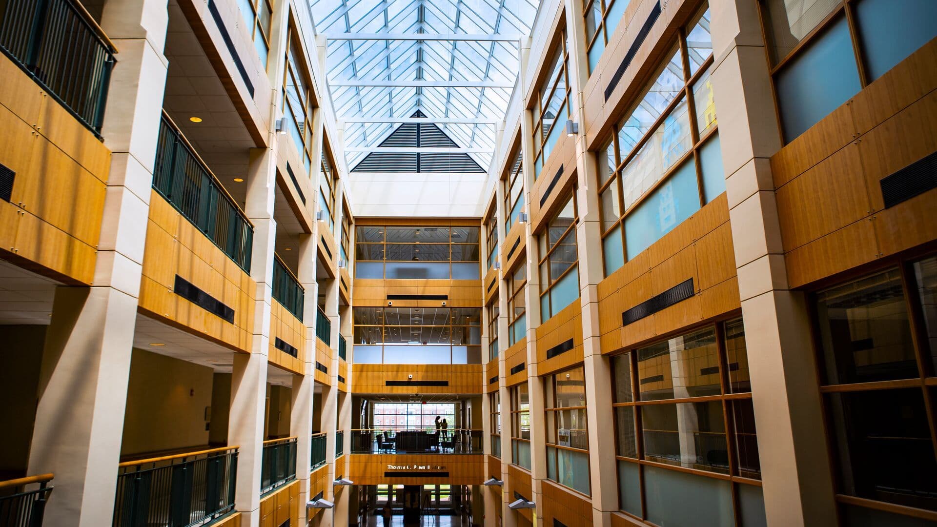 View of the interior atrium area of Van Munching Hall, view of the interior hallways and student silhouettes in the background.