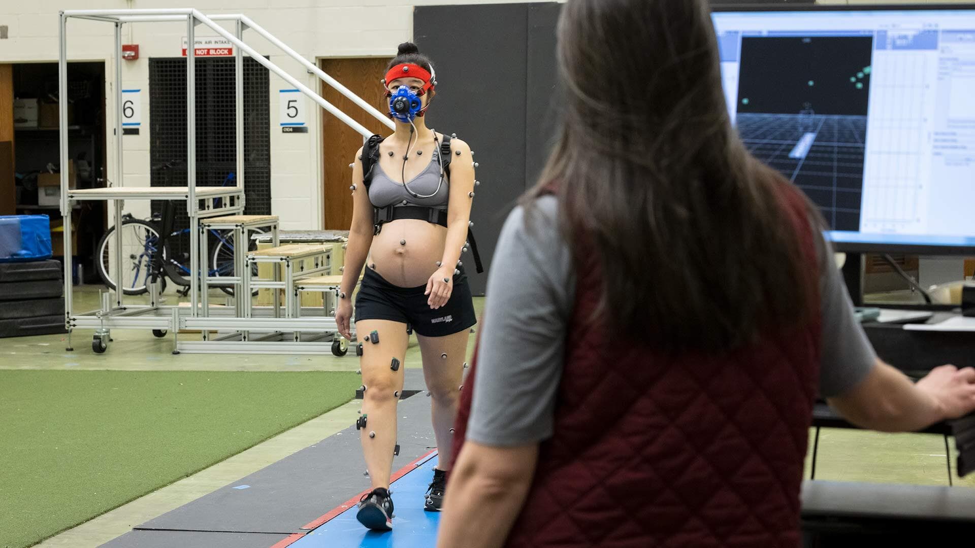 Karen Shih walks covered in sensors for a study on gait changes in pregnancy