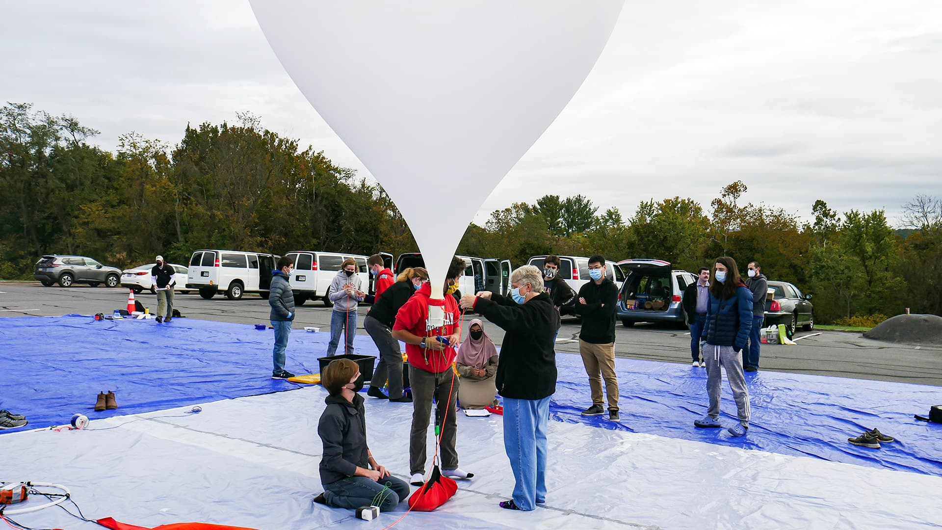 students and faculty member prepare to release a weather balloon